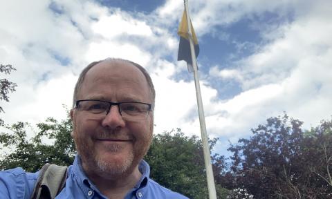 George Freeman MP in front of the Norfolk Flag